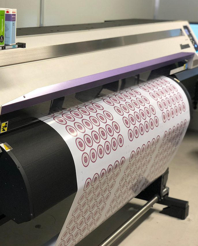 Wide-format printer running a sheet of self-adhesive labels